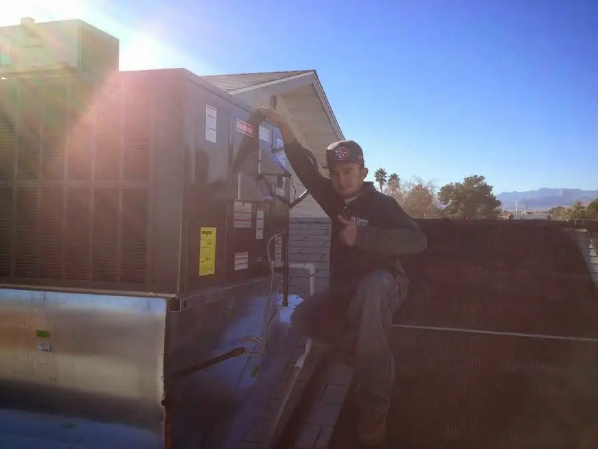 HVAC technician performing Air Duct Cleaning on a rooftop unit in Lockwood
